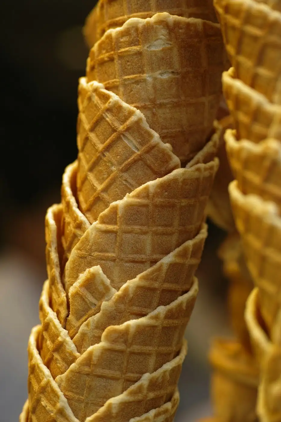 A tall stack of golden waffle cones